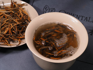 Steeping Golden Buds Classic Dianhong tea leaves in a ceramic gaiwan