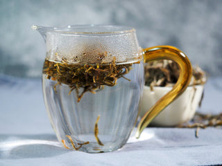 Golden-hued yellow tea leaves infusing in hot water, revealing floral and toasty aromas.