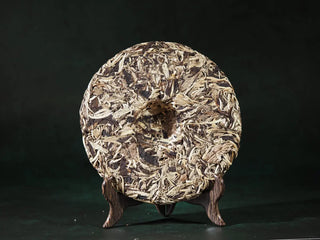 Back view of unwrapped Yunnan Jinggu White Peony Tea Cake 357g, showing leaf texture and craftsmanship