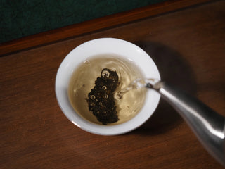 Brewing sample of YXT Jingyang Golden Flower Fu Tea First Grade 300g leaves placed in a porcelain gaiwan.