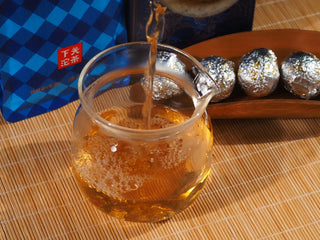 Pouring the brilliant amber-orange tea liquor of 18-year aged wild raw Puerh.