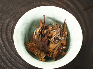 Dry 2018 sun-dried Fuding Shou Mei tea leaves placed in a white ceramic gaiwan before brewing, photographed from above.