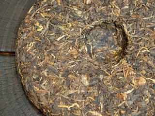The back center dimple (woutou) of the compressed 2006 raw Puerh tea cake showing authentic stone-mold pressing technique.