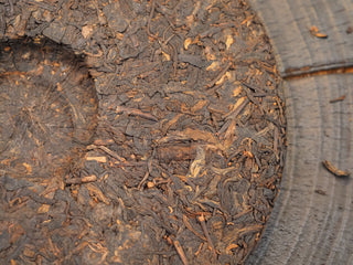 Close-up texture on the back side of 2019 Dayi 7592 ripe puerh tea cake, highlighting the compressed tea leaves pattern.