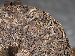 Close-up of back surface of 2018 Dazhai Ancient Tree Raw Pu-erh Tea Cake, highlighting aged leaves