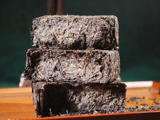 Stack of Hand-Pressed Fubrick showing the moderate tightness and the Yunnan Black Tea leaves cross-section.