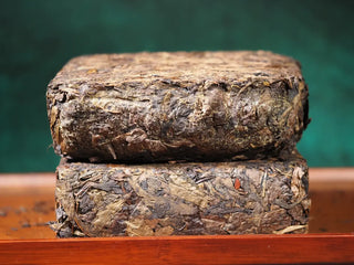 Jingyang Golden Flower Fu Brick Tea broken in half, stacked to show the dense golden flowers (Eurotium cristatum) inside the 1kg dark tea brick.