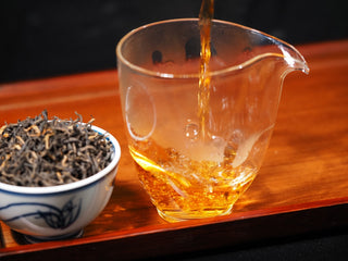 Pouring Vintage 2023 Premium Dianhong tea into glass pitcher