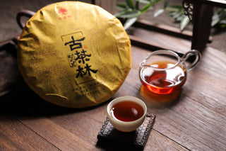Deep burgundy Pu-erh tea liquor served in a cup with the 2018 tea cake