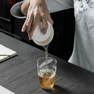 Preparing fresh tea infusion using a classic white porcelain gaiwan