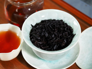 Wet leaves of traditional Da Hong Pao after steeping, showing authentic charcoal roasting.