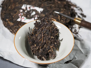 Close-up of a piece of Sticky Rice Aroma Raw Pu-erh Cake 2013 200g placed inside a gaiwan