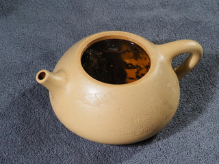 High-quality dark tea leaves ready for steeping in a ceramic teapot.