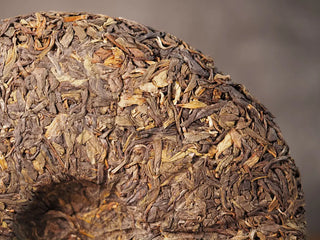 Close-up of the back side of Value Classic 2008 Tribute Sheng Pu-erh Tea Cake – 357g Menghai (2019 Pressed), showing leaf compression detail