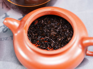 Wet, delicate tea buds of Imperial Grade Puerh inside a teapot after brewing, showing the tender "Imperial" leaf standard.
