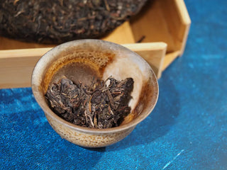 Spring Ming 2017 Aged Sheng Pu-erh Tea Cake – 400g (Lincang, Yunnan) placed in a gaiwan, ready for brewing, showing compressed leaves.
