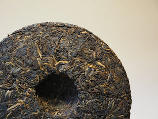 Center depression view of the compressed 2005 Lincang Sheng Pu-erh tea cake showing traditional stone-press manufacturing.