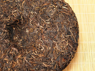 Close-up of the center dimple on Jing Chang Hao Mengsong Autumn Harvest 2013 raw Pu-erh cake, thick arbor leaf texture