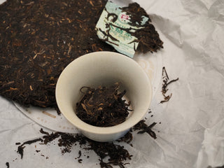 High-quality loose tea leaves from 2019 Dayi 8542 raw puerh cake inside a white gaiwan