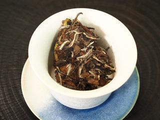 Dry 2020 Fuding White Peony leaves loaded into a white porcelain gaiwan before brewing, showing the bud-and-leaf composition.