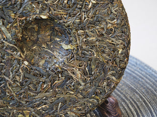 Center indentation and compression detail of the 2025 Tan Chun raw Puerh tea cake.