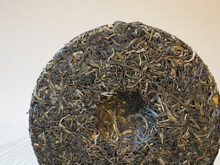 Center indentation and compression detail of the 2026 Tan Chun raw Puerh tea cake.