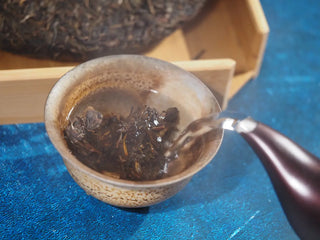 Pouring hot water over Spring Ming 2017 Aged Sheng Pu-erh Tea Cake – 400g (Lincang, Yunnan) in a gaiwan, beginning the infusion process.