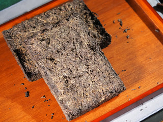 A piece of YXT Jingyang Fu Tea Ximanzi 2018 brick broken off, displaying the internal structure and color of the aged Fuzhuan Cha.