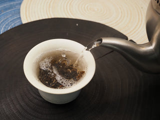 Hot water being poured over 2019 Dayi 8542 raw puerh tea leaves