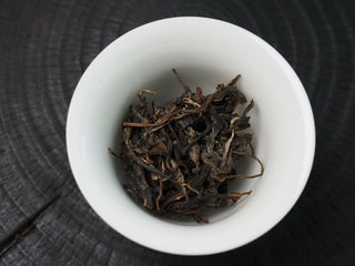 2020 Dazhai Ancient Tree Raw Pu-erh Tea – Dry Loose Leaves in White Porcelain Cup Showing Golden Brown Color and Bud Quality
