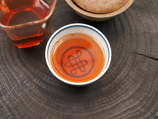 Rich red liquor of 2024 Bulang Mountain bold ripe pu-erh in a tea cup