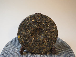 Backside view of the 2025 Tan Chun ancient tree raw Puerh tea cake.