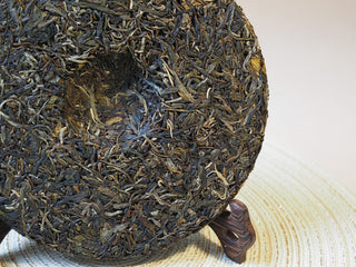 Backside view of the 2026 Tan Chun ancient tree raw Puerh tea cake.
