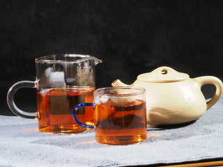 Full tea service showing the amber liquor and clay teapot of On Taoism Fu Brick Tea.