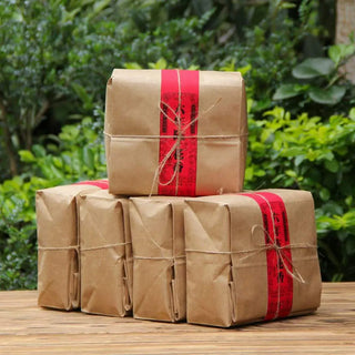 Stacked bundles of rose scented ripe puerh tea ready for shipping, emphasizing authentic origin.