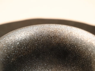 Close-up of the rim texture of a wood-fired stoneware gaiwan from Dehua Fujian, rough granular kiln-change glaze surface.