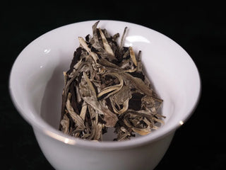 Another close-up of a piece of Yunnan Jinggu White Peony Tea Cake 357g in a gaiwan, showing tender buds and first leaves
