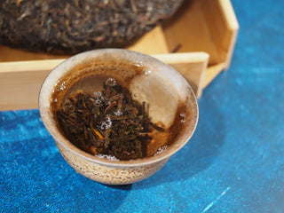 Spring Ming 2017 Aged Sheng Pu-erh Tea Cake – 400g (Lincang, Yunnan) fully steeped in a gaiwan, displaying rich amber tea liquor and unfurling leaves.