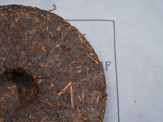 Macro shot of the traditional center dimple on the back of 2006 Dayi 7572 ripe Puerh cake