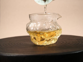 Golden amber tea liquor from 2018 Fuding Shou Mei cake poured from a gaiwan into a clear glass fairness pitcher.