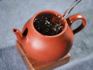 Brewing process of On Taoism Golden Flower Fu Brick Tea with hot water.