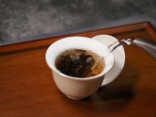 Pouring hot water into Gaiwan with Qilin Hao Fengshan Gushu Ripe Pu-erh Tea Cake 2021 to start infusion