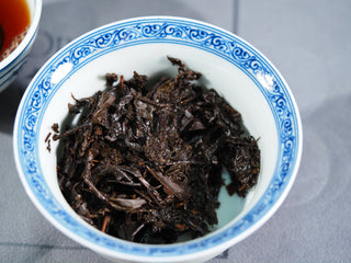 Wet tea leaves of the aged Fu Brick after brewing, displaying the thick and sturdy heritage leaf quality.
