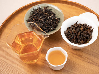 Top view of Yunnan Golden Empress Oolong tea tasting set and tea leaves