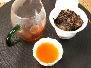Full gongfu brewing scene of 2013 Fuding Shou Mei: pitcher of red liquor, gaiwan with infused leaves, and a tasting cup.