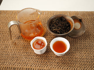 Gongfu tea session with Jing Chang Hao Quiet Years 2018 raw Pu-erh: glass fairness pitcher, gaiwan with wet leaves and two cups of amber liquor