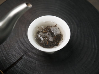 2020 Dazhai Ancient Tree Raw Pu-erh Tea – Infused Wet Leaves in White Cup Showing Tender Even Yellow-Green Leaf Base
