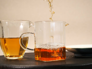 Side-by-side comparison of two steepings of 2020 Fuding White Peony — pale gold on the left, deep reddish amber on the right.