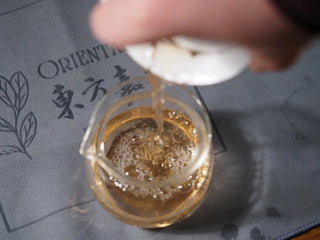 2018 Dazhai Ancient Tree Raw Pu-erh Tea Cake brewed tea being poured from gaiwan into gongdao cup