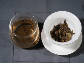Brewed Mengku TeaSoul Sheng Pu-erh Coin Tea showing tea leaves in gaiwan and golden liquor in gongdao cup